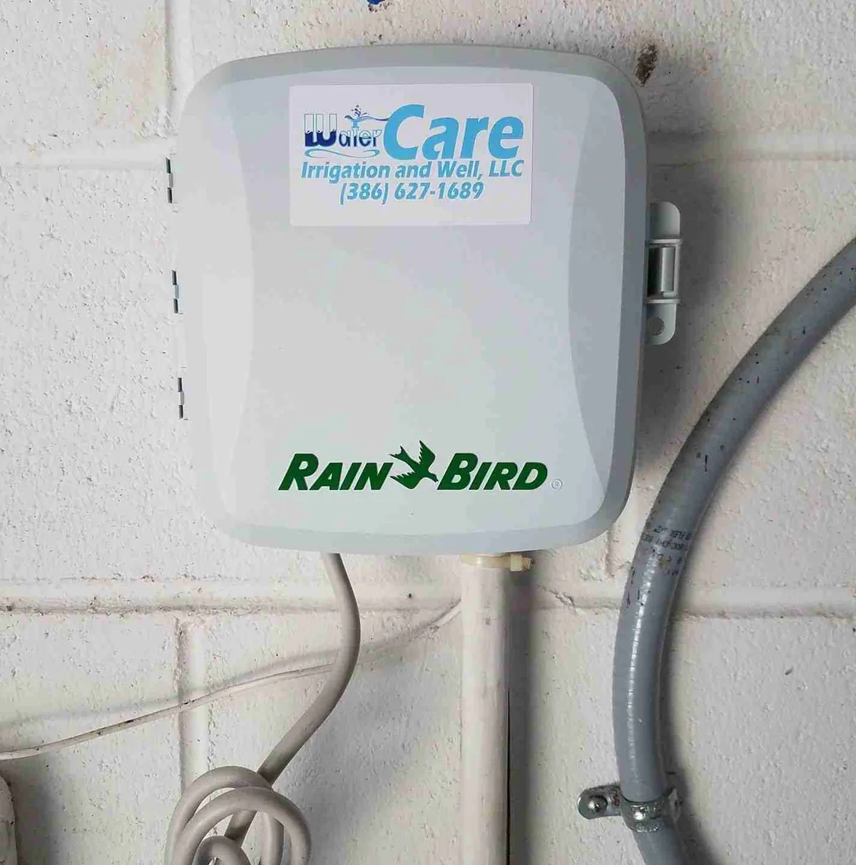 WaterCare technician programming a Rain Bird irrigation controller after seasonal service